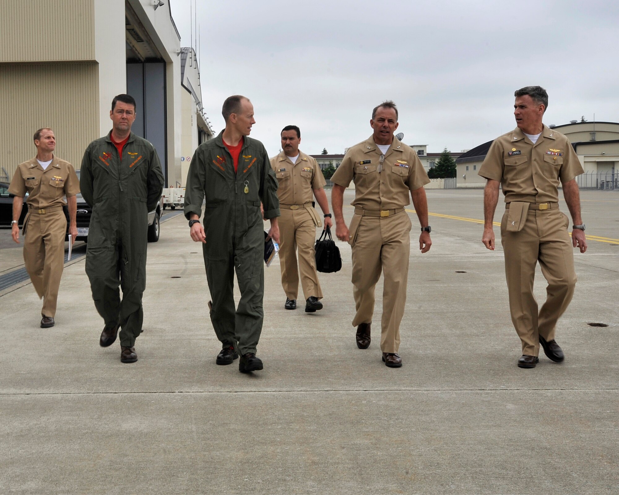 Rear Adm. Terry Kraft, U.S. Naval Forces Japan commander, second from right, walks onto the Naval Air Facility (NAF) Misawa flight ramp with Cmdr. William McCombs, center, Electronic Attack Squadron 132 commanding officer, and Capt. Chris Rodeman, right, NAF Misawa commanding officer, June 19, 2014. Kraft is currently visiting Naval Air Facility Misawa and meeting with Sailors, and touring the installation’s various facilities. He'll also take part in the NAF Misawa Change of Command Ceremony, June 20. (U.S. Navy photo by Senior Chief Mass Communication Specialist Daniel Sanford/Released)