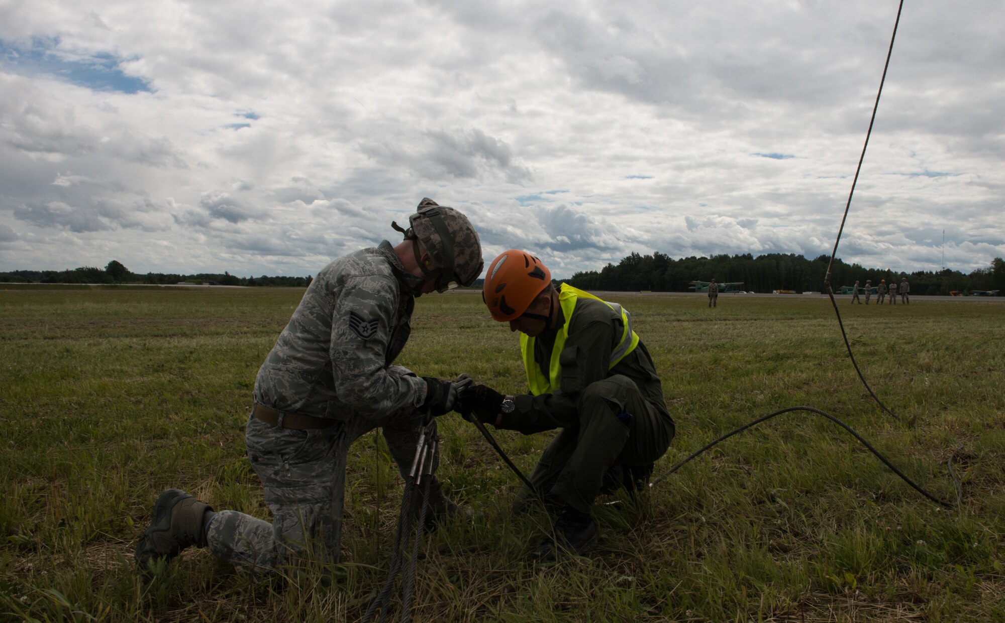 Airmen from the 435th Contingency Response Group attach a bundle onto a Latvian Mi-8 helicopter electorate in part of sling-load operations training during the Air Force-specific portion of Saber Strike at Lielvarde Air Base, Latvia, June 17, 2014. During the final week of Saber Strike 2014 the 435th CRG, in conjunction with the 37th Airlift Squadron, trained on the full capabilities to open the Latvian air base. They also trained with Latvian and Estonian service members on airfield operations, command and control of air and space forces, weather support, and protection of operational forces, aircraft maintenance and aerial port services. (U.S. Air Force photo/Senior Airman Jonathan Stefanko)