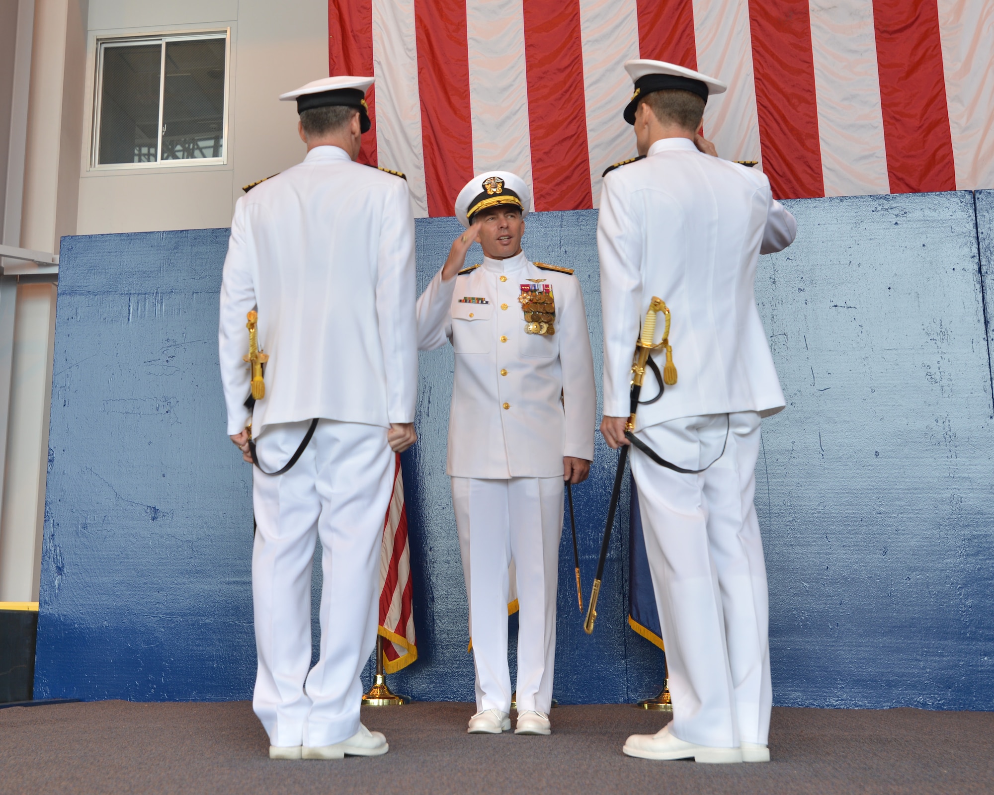Rear Adm. Terry Kraft, center, U.S. Naval Forces Japan commander, returns a salute from Capt. Keith Henry, right, originally from Cheshire, Connecticut, during the Naval Air Facility (NAF) Misawa Change of Command Ceremony, June 20, 2014.  Henry assumed command of NAF Misawa from Capt. Chris Rodeman, becoming the 18th commanding officer in installation history. NAF Misawa is a U.S. naval base located in northern Japan. (U.S. Navy photo by Mass Communication Specialist 3rd Class Erin Devenberg/Released)