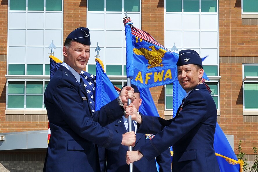 OFFUTT AIR FORCE BASE, Neb. -- U.S. Air Force Brig. Gen. Eric S. Overturf, Air Force mobilization assistant to the director of operations, deputy chief of staff for operations, plans and requirements, hands the Air Force Weather Agency guidon as presiding official to U.S. Air Force Col. William Carle during a change of command ceremony outside the Lt. Gen. Thomas S. Moorman headquarters building June 18. Carle took command from U.S. Air Force Col. Louis Zuccarello, who is retiring after nearly 30 years of service. (Photo by Charles Haymond)