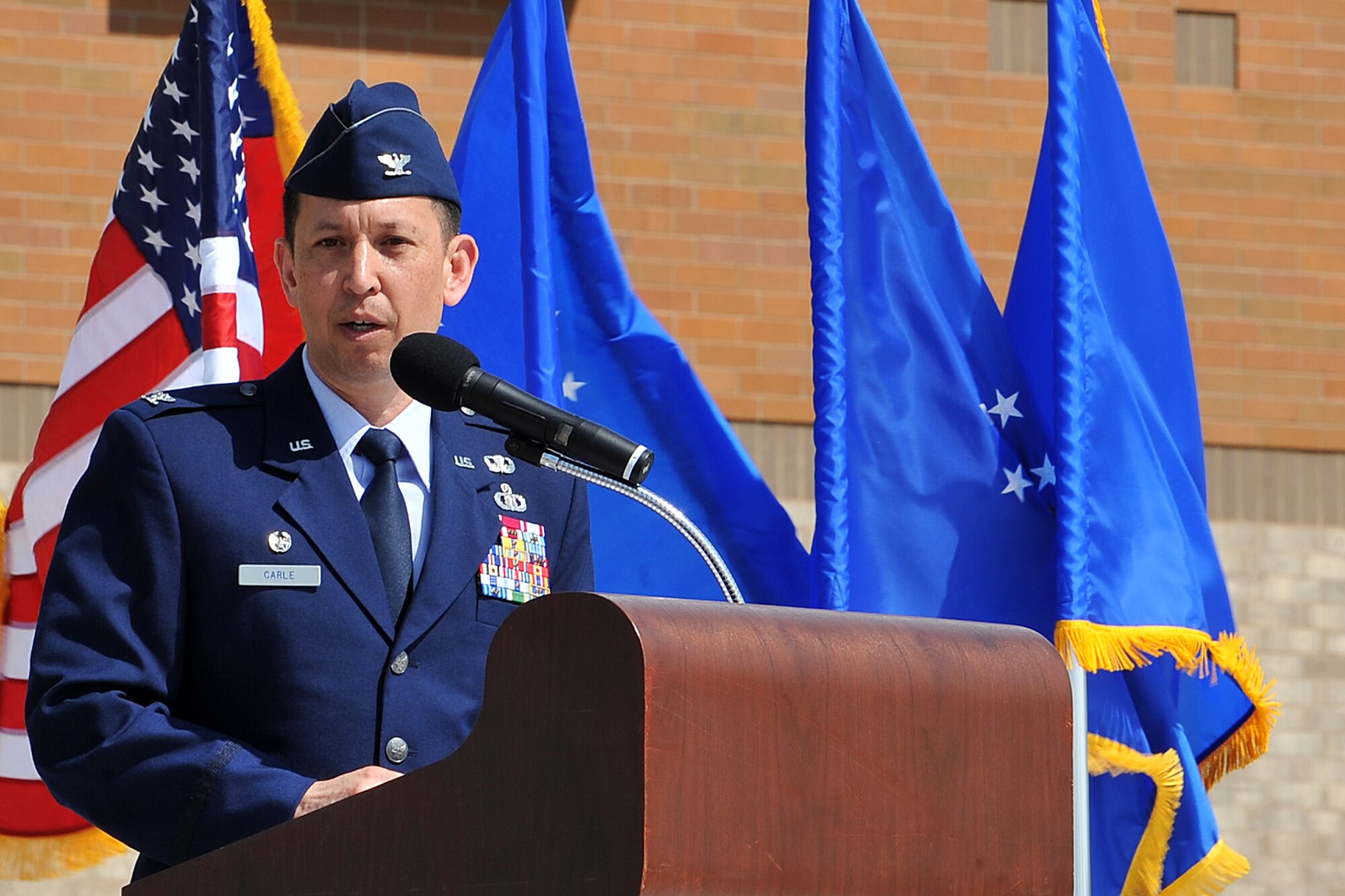 OFFUTT AIR FORCE BASE, Neb. -- U.S. Air Force Col. William Carle, Air Force Weather Agency commander, speaks after taking commnad from Col. Louis Zuccarello during a ceremony outside the Lt. Gen. Thomas S. Moorman headquarters building June 18. Carle had been serving as the 1st Weather Group commander since June 2012. (Photo by Charles Haymond)