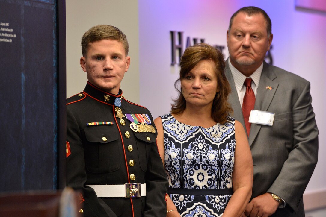 Defense Secretary Chuck Hagel, not shown, recognizes Medal of Honor recipient retired Marine Corps Cpl. William “Kyle” Carpenter, shown with his parents, during a Hall of Heroes induction ceremony at the Pentagon, June 20, 2014. President Barack Obama presented Carpenter with the Medal of Honor during a White House ceremony, June 19, for his actions while deployed in Helmand Province, Afghanistan, in 2010.
