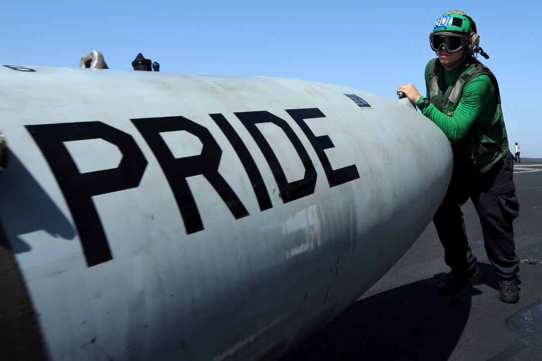 A U.S. sailor moves a fuel sponson on the flight deck of the aircraft carrier USS George H.W. Bush in the Persian Gulf, June 18, 2014.