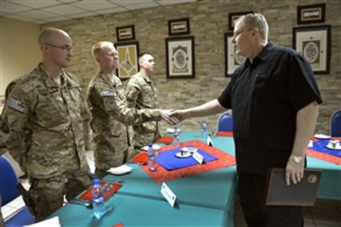 U.S. Deputy Defense Secretary Bob Work introduces himself to enlisted service members as he joins them for dinner in the dining facility at the International Security Assistance Force headquarters in Kabul, Afghanistan, June 23, 2014. Work is visiting Afghanistan to meet with leaders.