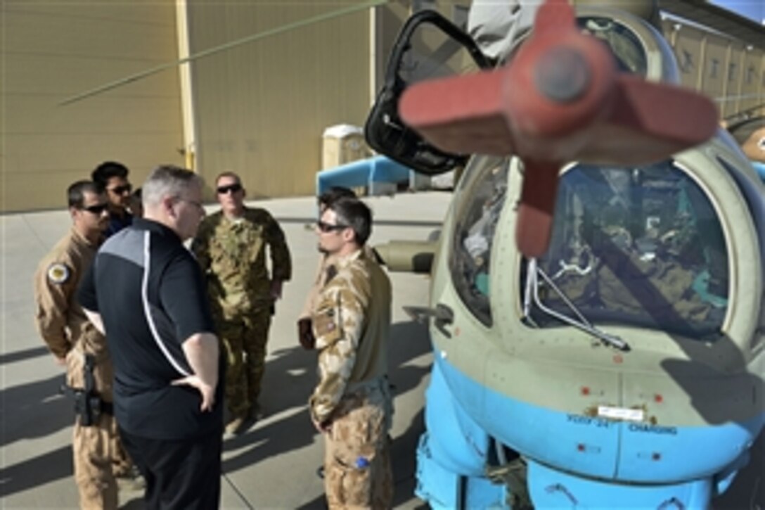 U.S. Deputy Defense Secretary Bob Work, left, visits with Afghan crewmen as he tours a static display of a Russian built helicopter in Kabul, Afghanistan, June 22, 2014. 