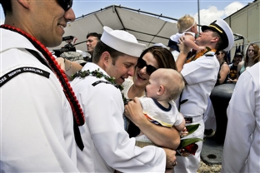 Navy Petty Officer 1st Class Mike Allred reunites with his family on the pier following the return of the attack submarine USS North Carolina  to Joint Base Pearl Harbor-Hickam in Honolulu, June 19, 2014, after completing a deployment to the western Pacific region. The North Carolina conducted operations and theater security exercises to contribute to the nation's strategic posture in the region. Allred is an electronics technician.