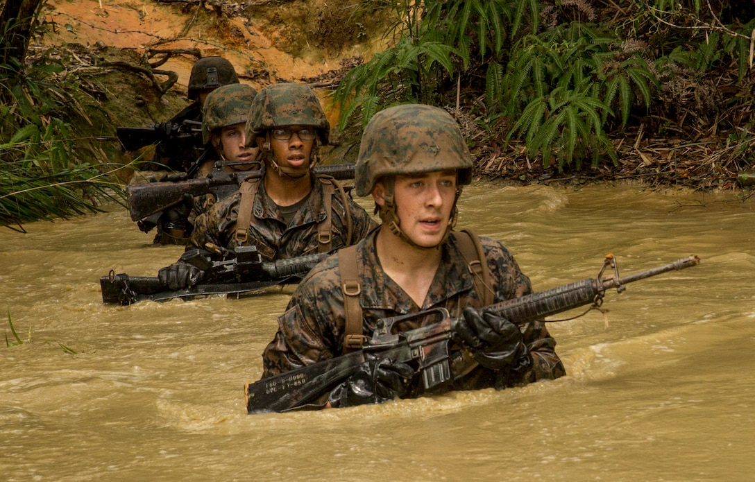 Marines and sailors maneuver through waist-deep, muddy water during the jungle endurance course June 20 at the Jungle Warfare Training Center, Camp Gonsalves, Marine Corps Base Camp Smedley D. Butler, Marine Corps Installations Pacific. The variation of obstacles, exceedingly humid weather and harsh terrain added immeasurably to the strenuousness of the course, according to Cpl. James E. King, a warehouse clerk with 1st Battalion, 8th Marine Regiment, which is currently assigned to 4th Marines, 3rd Marine Division, III Marine Expeditionary Force, under the unit deployment program. The Marines and sailors are with the battalion. (U.S. Marine Corps photo by Lance Cpl. Diamond N. Peden/Released)
