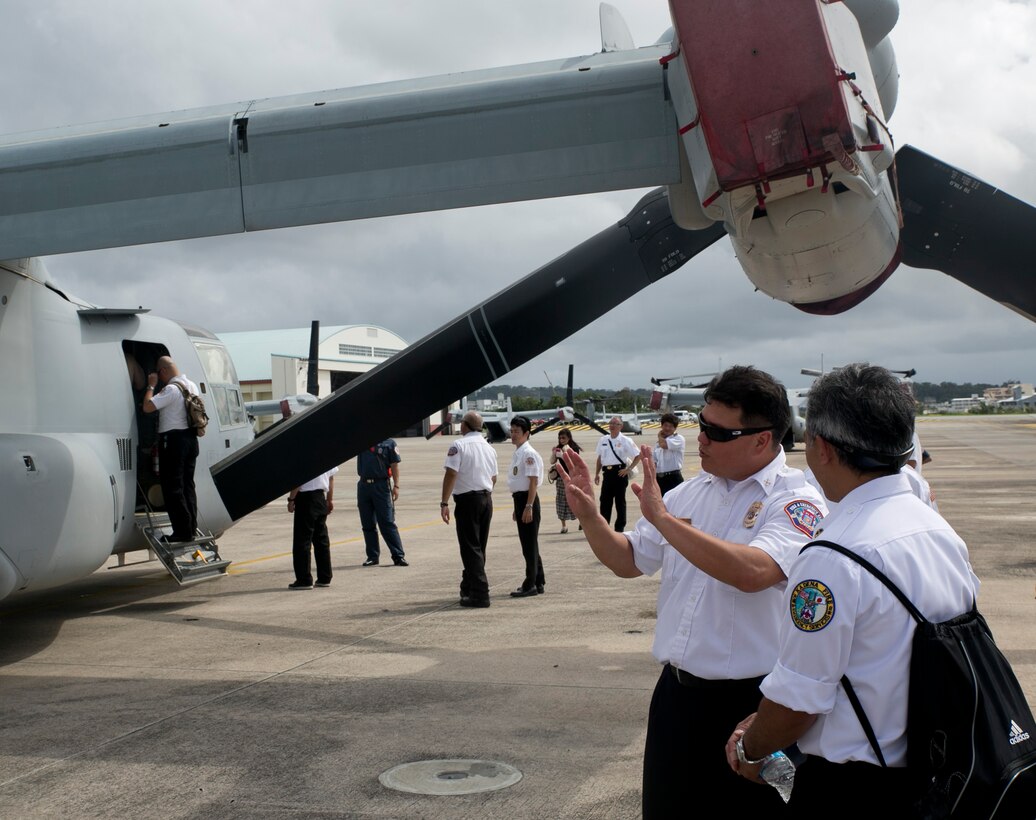 John Arakaki, second from right, and Yuji Nakayama discuss the firefighting capabilities of the MV-22B Osprey tiltrotor aircraft during the MLC Senior Officer Session June 10 at Marine Corps Air Station Futenma. The event was an opportunity for many of the senior fire officers to share knowledge about their trade. Arakaki is the battalion chief for Fire and Emergency Services with the Marine Corps, Nakayama is the district chief for Fire and Emergency Services with the Air Force. Both are Okinawa, Japan, natives. (U.S. Marine Corps photo by Lance Cpl. Tyler Ngiraswei/ Released)