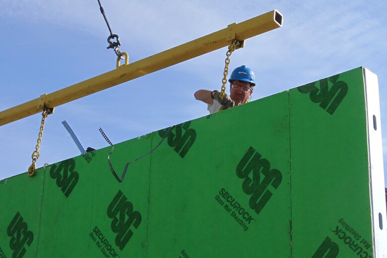 FORT LEE, Va.  --A contractor prepares a pre-fabricated exterior wall to be lifted by crane into place at the Fort Lee Advanced Individual Training Phase II project, June 6, 2014. The project includes a five-story, 300-person addition to an existing barracks building, as well as a separate five-story, 600-person barracks facility. (U.S. Army photo/Patrick Bloodgood)