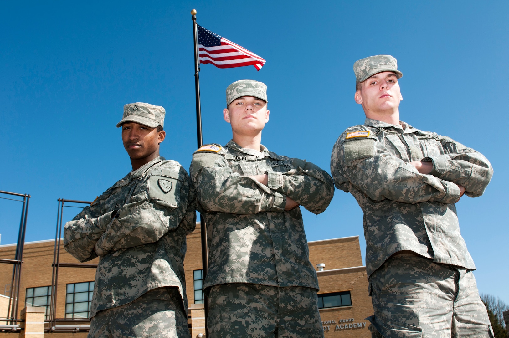 Army Pfc. David Huff, Army Pvt. Tylor Dolfi, and Army Pvt. Evan Dancer, stand proudly in front of the National Guard Patriot Academy at the Muscatatuck Urban Training Center, Ind., Feb. 17, 2012. The three Alaska Army National Guard members are attending the National Guard Patriot Academy and are currently on track to earn their high school diplomas by the end of the summer.