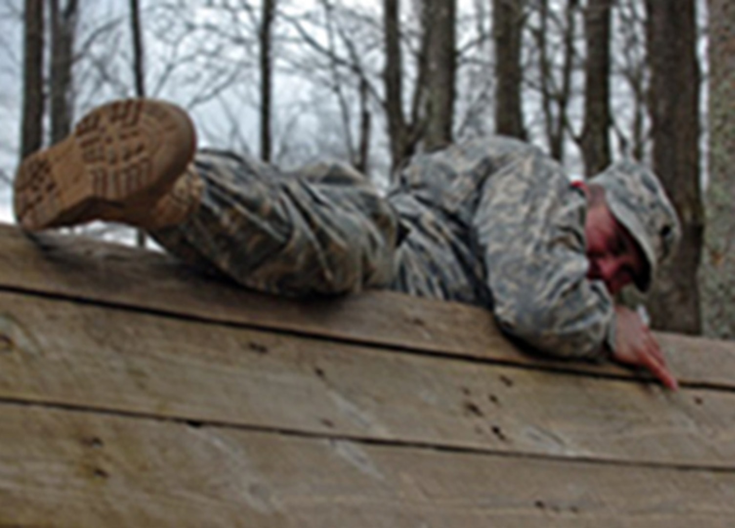 Army Spc. Derek Thrasher, from the Directorate of Plans, Training, and Mobilization office at Camp Atterbury Joint Maneuver Training Center, Ind., climbs a five-foot wall March 4, 2012 here during a qualification competition for the 2012 Indiana Soldier and Noncommissioned Officer of the Year competition. The three-day competition included several events to determine the best qualified to compete in the state competition.