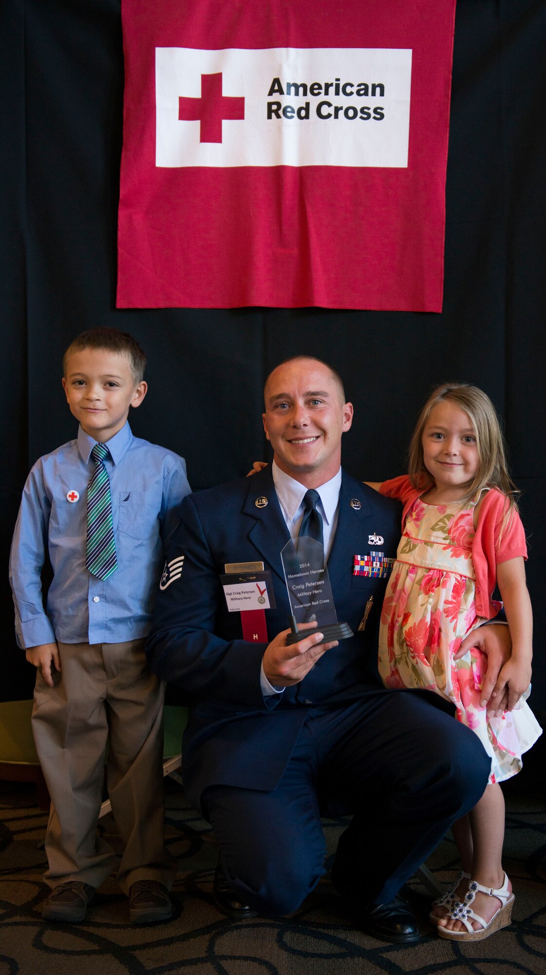 Staff Sgt. Craig Petersen poses with his son and daughter after the American Red Cross Hometown Hero Awards ceremony June 19, 2014, in Boise, Idaho. Petersen was honored for treating the wounds of a car crash victim until authorities arrived to the scene. (U.S. Air Force photo/Airman 1st Class Malissa Lott)