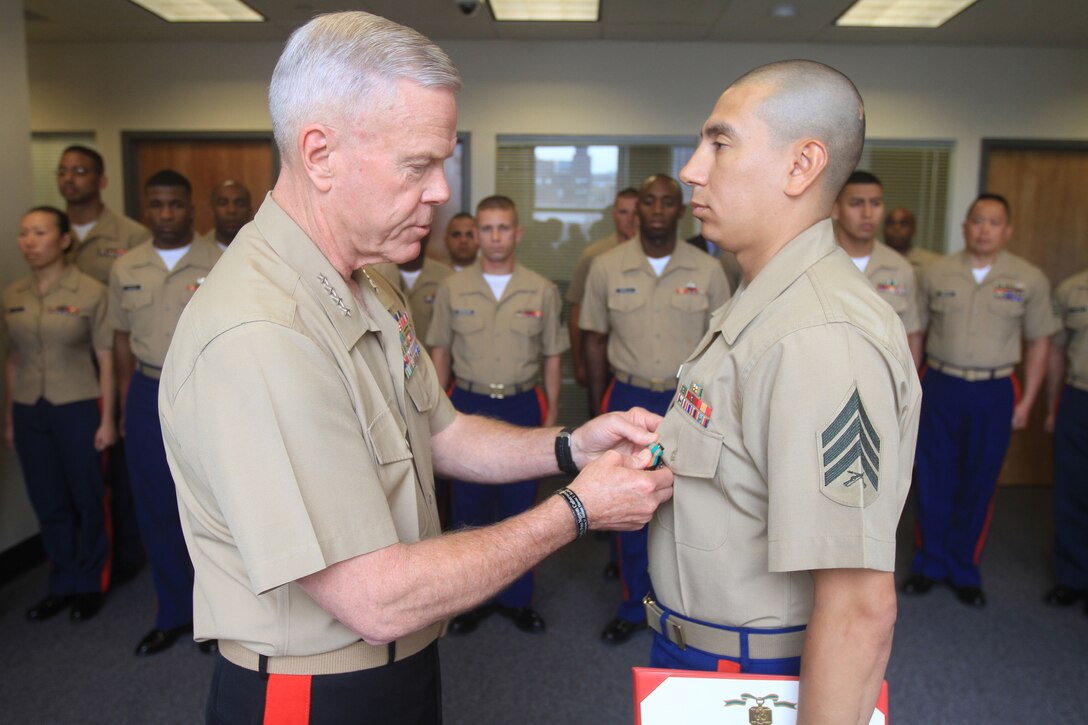 Sgt. Julio Chicas, staff noncommissioned officer-in-charge of Recruiting Substation Jamaica, receives a Navy and Marine Corps Achievement Medal from Gen. James F. Amos, Commandant of the Marine Corps, during a visit to Recruiting Station New York June 13.