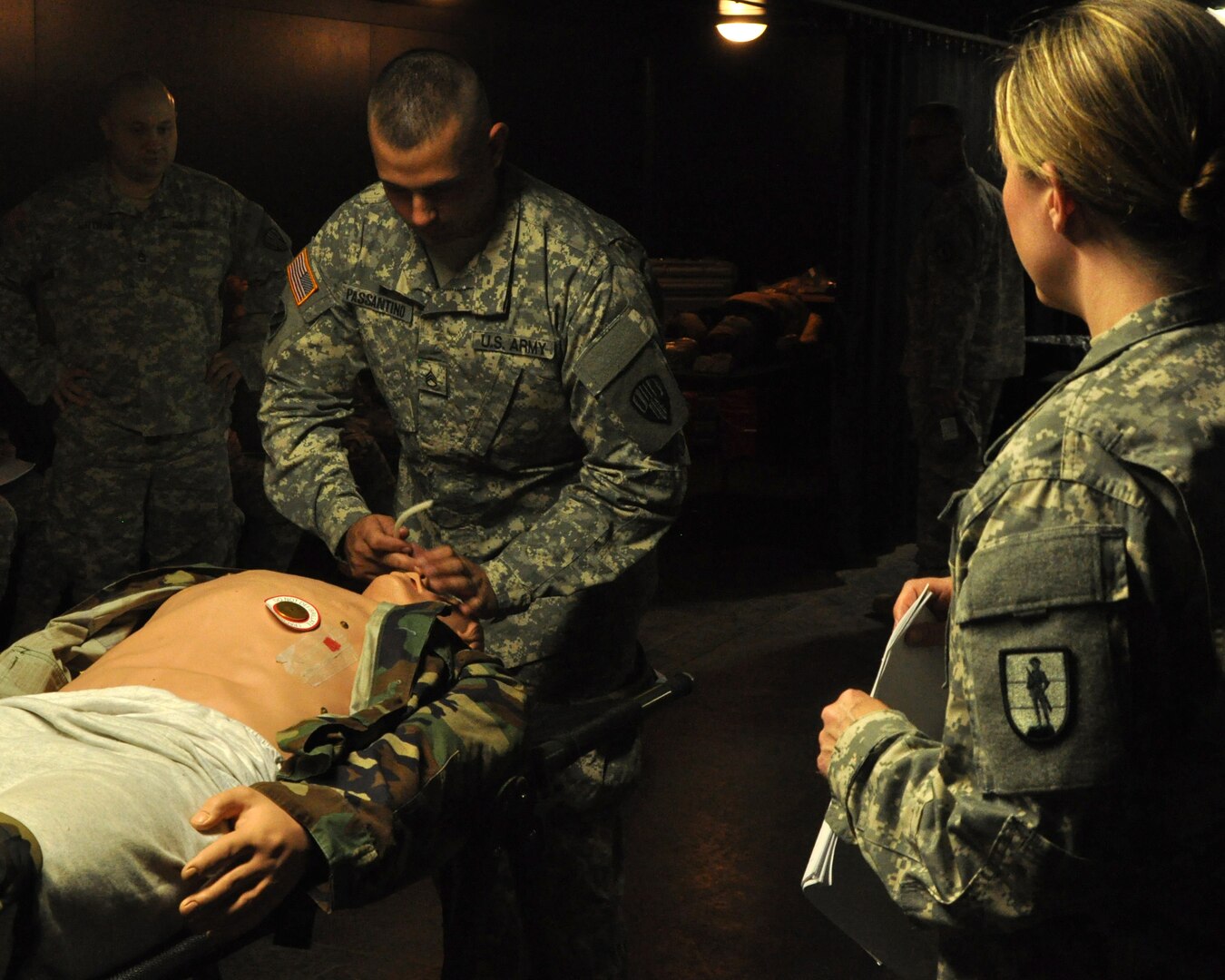 New York National Guard Staff Sgt. James Passantino, a member of the  727th MP Detachment, checks the  airway on a training mannequin during Combat Lifesaver Training conducted by the 106th Regional Training Institute here on Saturday, June 21, as Staff Sgt. Dara Cunningham, an instructor, watches.