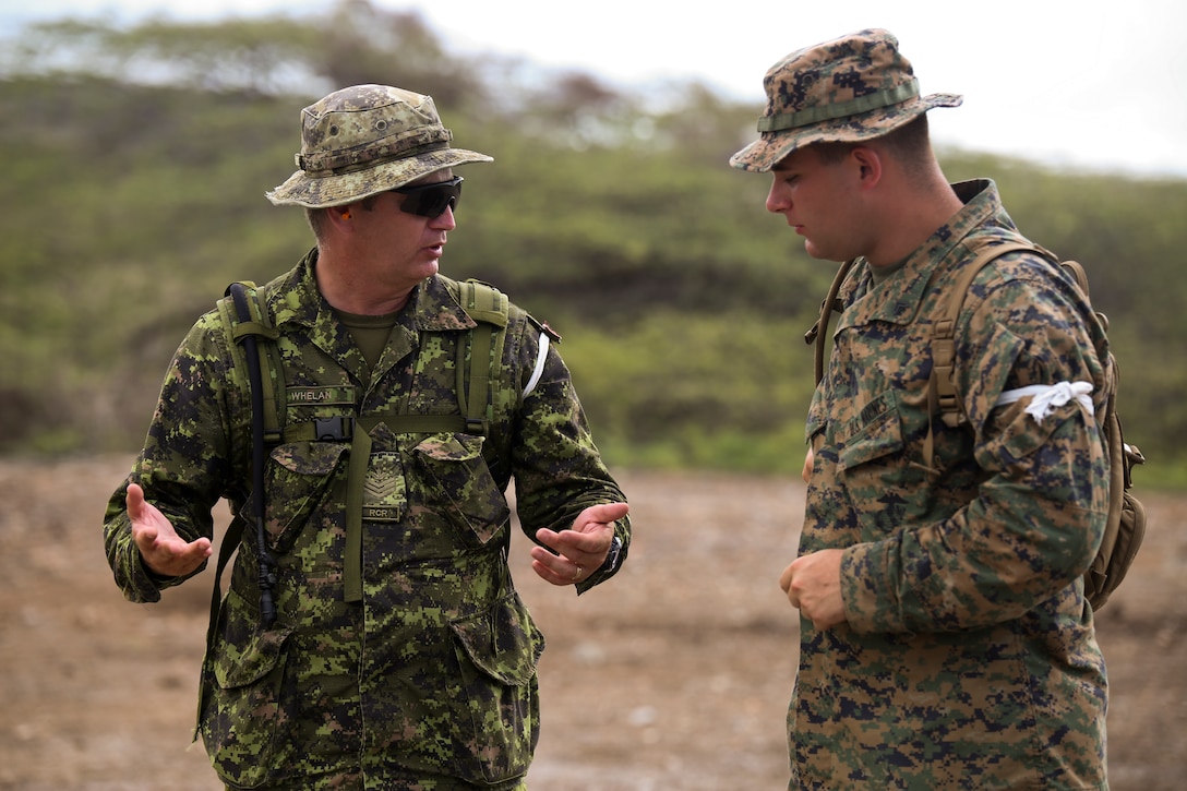 Sgt. Neil Whelan, range staff with Northshore New Brunswick Regiment, Royal Canadian Regt., explains range operations to Cpl. John King-Kaplan, a fireteam leader with Company C, 4th Law Enforcement Battalion, during a range when the Marines and Canadian soldiers came together to train partner nations on M4 Benelli Tactical Shotguns aboard Las Calderas Naval Base, Dominican Republic, June 21, 2014. U.S. Marines with C Co., 4th LE Bn., Force Headquarters Group, Marine Forces Reserve, and soldiers with the Canadian Army are training police forces and militaries from 13 partner nations participating in phase II of Tradewinds 2014 held from June 16 through June 25. Tradewinds 2014 is a joint, combined exercise conducted in order to improve partner nation counter-transnational organized crime missions and humanitarian aid and disaster response operations capacity. The exercise is also designed to promote interoperability and multinational relationships throughout the theater. (U.S. Marine Corps photo by Sgt. Jessica Ito/Released)