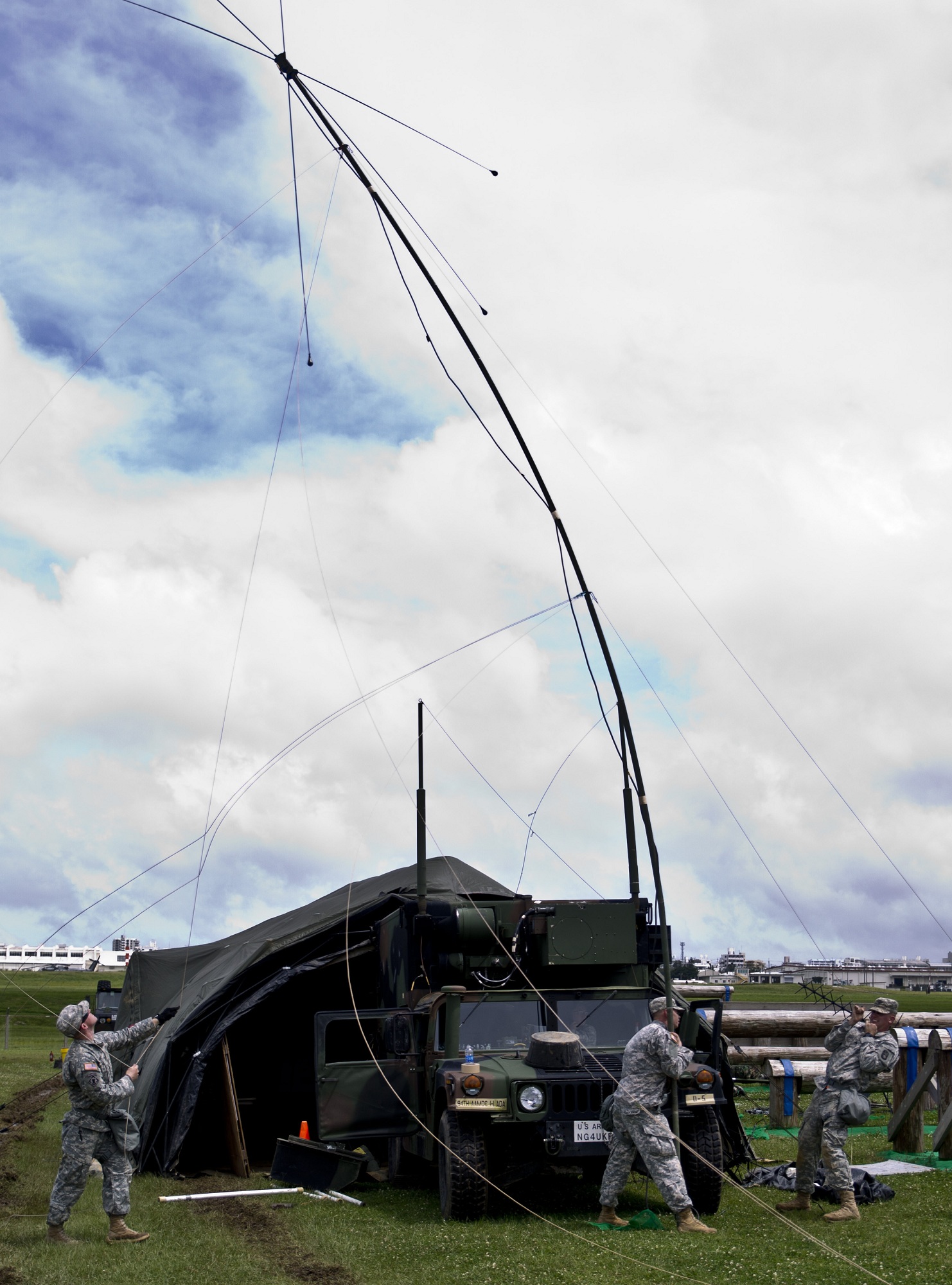 U.S. Army soldiers set up an OE-254 antenna group during a training exercise June 17 at Marine Corps Air Station Futenma. The antenna group allows the soldiers to communicate with other U.S. military installations across Okinawa. While away from their home station of Kadena Air Base, the training event had soldiers working around the clock to train for rapidly setting up and tearing down radios and antennas, checking and drawing information from data sheets, and training as if a hostile missile were in the sky. The soldiers are with Battery D, 1st Battalion, 1st Air Defense Artillery Regiment, 94th Army Air and Missile Defense Command.