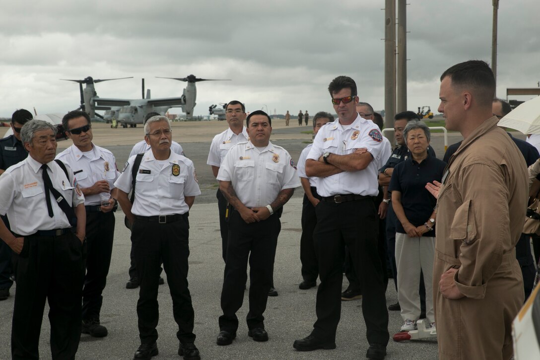 U.S. Marine Capt. Jason Noll, far right, explains the capabilities of a Bambi Bucket firefighting water delivery system and the MV-22B Osprey tiltrotor aircraft to senior fire officers at the MLC Senior Officer Session June 10 at Marine Corps Air Station Futenma. The fire officers were there as part of a three-day event, at different bases in Okinawa, that showcased the capabilities of firefighting techniques and equipment, the Osprey and the Bambi Bucket. Noll is a Kirksville, Missouri, native and pilot with Marine Medium Tiltrotor Squadron 265, Marine Aircraft Group 36, 1st Marine Aircraft Wing, III Marine Expeditionary Force. (U.S. Marine Corps photo by Lance Cpl. Tyler Ngiraswei/Released) 