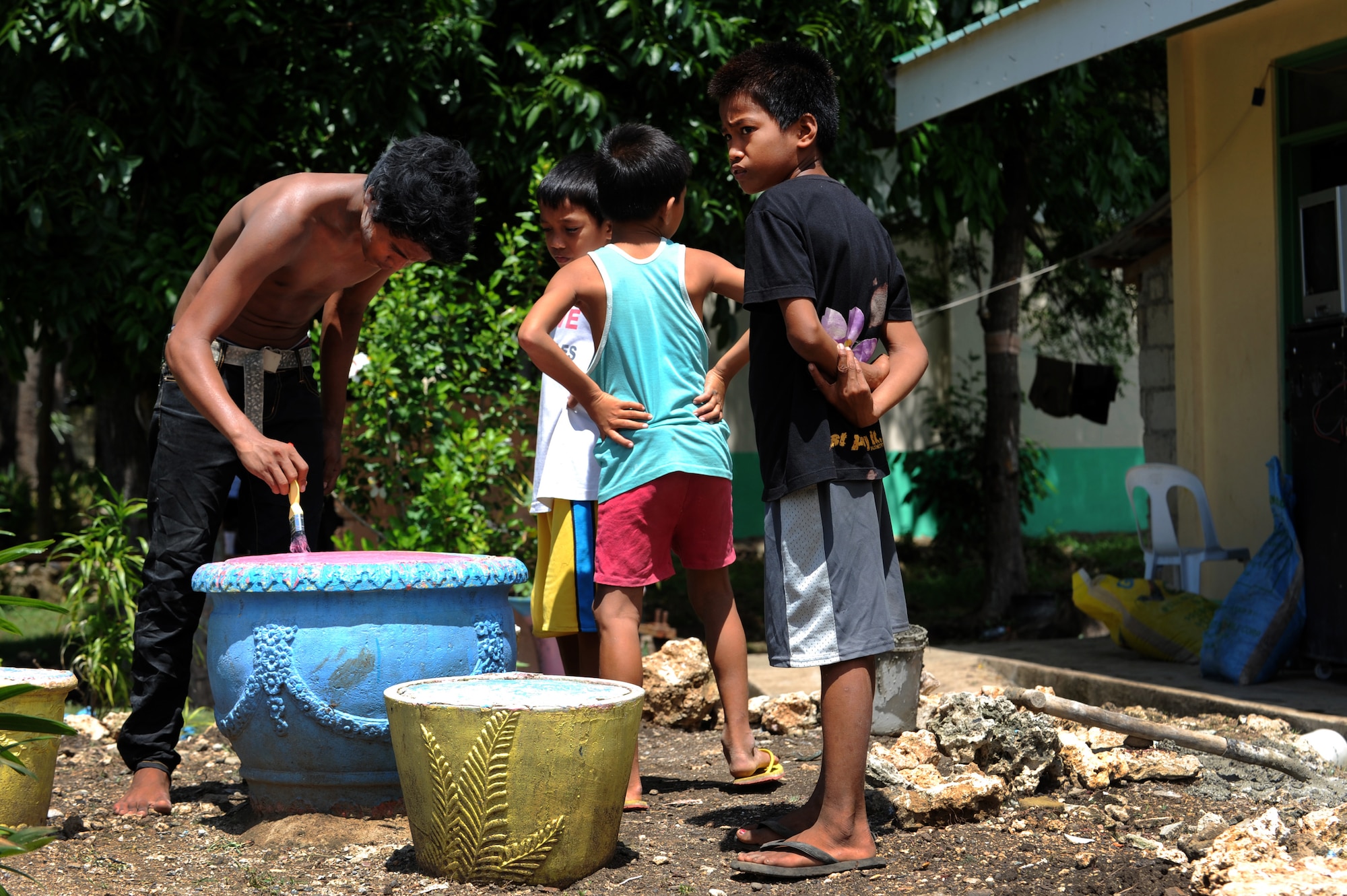 Elementary students repaint planters in a playground area at Buyong Elementary School in Barangay Maribago, Lapu-Lapu City, Philippines June 18, 2014. The students cleaned and repainted areas around the school as they readied it for the closing ceremony of Operation Pacific Unity 14-6. Pacific Unity is a bilateral Engineering Civic Action Program conducted in the Asia-Pacific region in collaboration with host nation military personnel. Airmen from the 374th CES spent 31 days building two classrooms and renovating utilities throughout the school. (U.S. Air Force photo by Staff Sgt. Amber E. N. Jacobs/Released)