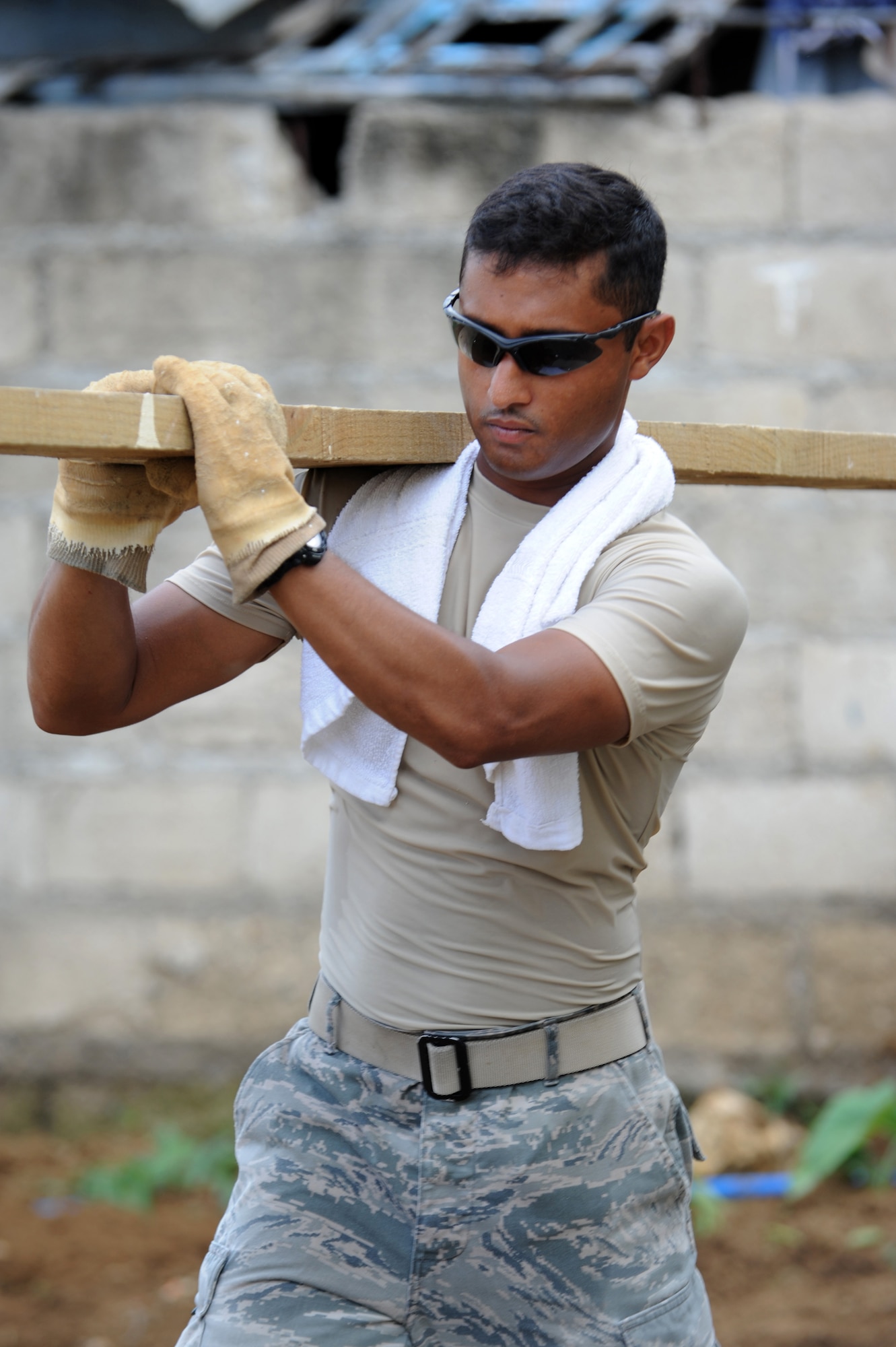 U.S. Air Force Senior Airman Ariful Haque, 374th Civil Engineer Squadron utilities journeyman, Yokota Air Base, Japan, carries a plank away from a construction site as cleanup begins at Buyong Elementary School in Barangay Maribago, Lapu-Lapu City, Philippines June 18, 2014. Airmen from the 374th CES spent 31 days building two classrooms and renovating utilities throughout the school as part of Pacific Unity 14-6, a bilateral engineering program meant to strengthen ties with regional partners throughout the Asia-Pacific region. (U.S. Air Force photo by Staff Sgt. Amber E. N. Jacobs/Released)