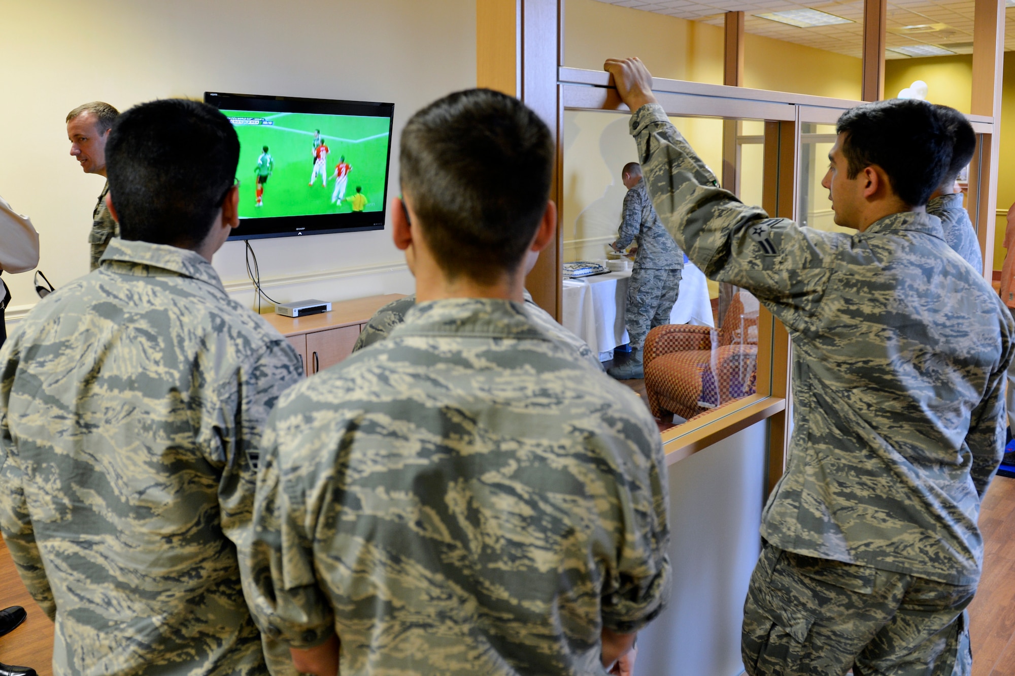 Airmen from the 62nd Aerial Port Squadron watch the World Cup on the big screen in McChord Field’s new passenger terminal family lounge during a ribbon cutting ceremony June 23, 2014, at Joint Base Lewis-McChord, Wash. Efforts to upgrade the lounge began in the spring of 2011 with construction starting in March of 2013. (U.S. Air Force photo/Staff Sgt. Russ Jackson)