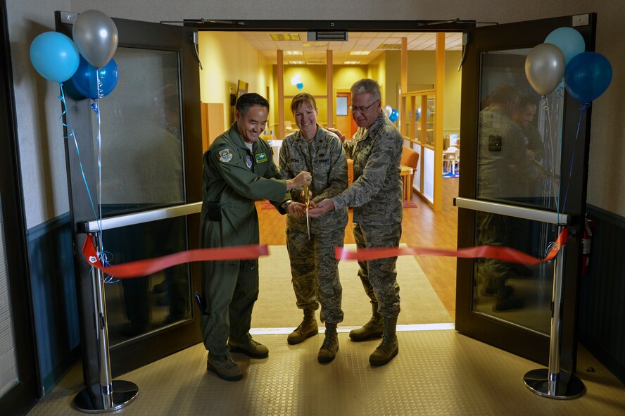 Col. David Kumashiro (left), 62nd Airlift Wing commander, Maj. Lisa Ryan, 62nd Aerial Port Squadron commander and Col. Bruce Bowers (right), 446th Airlift Wing commander, officially cut the ribbon opening McChord Field’s passenger terminal’s new family lounge June 23, 2014, at Joint Base Lewis-McChord, Wash. In 2010, Air Mobility Command made an effort to standardize passenger terminals around the world after noticing facility discrepancies between various terminals. (U.S. Air Force photo/Staff Sgt. Russ Jackson) 