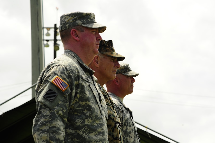 U. S. Army Col. Kirk C. Dorr, (left), U. S. Marine Gen. John F. Kelly, U. S. Southern Command commander, and U. S. Army Col. Thomas D. Boccardi watch as Joint Task Force-Bravo major support commands march in pass and review during a change of command ceremony at Soto Cano Air Base, Honduras, June 23, 2014.  Col. Dorr assumed command of Joint Task Force-Bravo from Col. Boccardi.  (Photo by Martin Chahin)