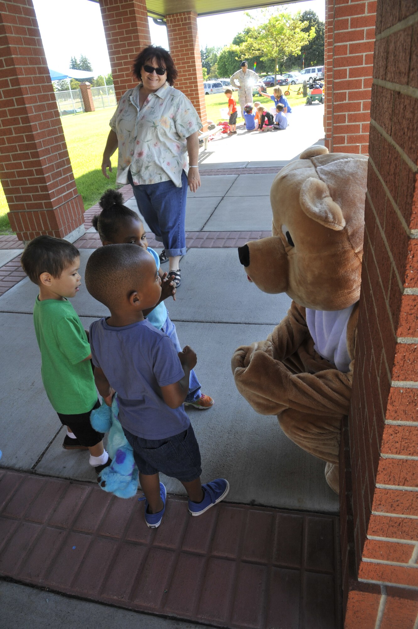 Children from the Child Development Center visit with "Teddy" the bear at Fairchild Air Force Base, Wash., June 20, 2014. Teddy, along with other members of the 92nd Medical Group, spent time explaining to children what happens in medical emergencies and what they should do if someone they know is hurt or needs help. (U.S. Air Force photo by Senior Airman Mary O'Dell/Released)