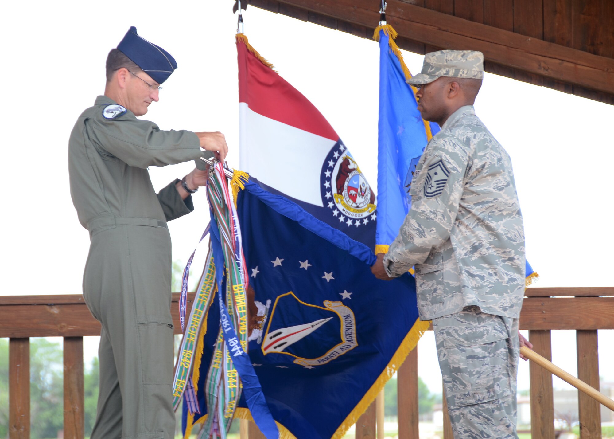 At the start of the131st Wingman Picnic culminating June 16-22, 2014, AT week activities, Col. Michael Francis, 131st Bomb Wing commander, with the assistance of Senior Master Sgt. Sheldon Matthews, added the 131st’s latest Air Force Outstanding Unit Award streamer – awarded in May – to the wing guidon, and thanked the wing’s members for a successful week and a strong start to the current calendar year. (U.S. Air National Guard photo by Staff Sgt. Brittany Cannon) 