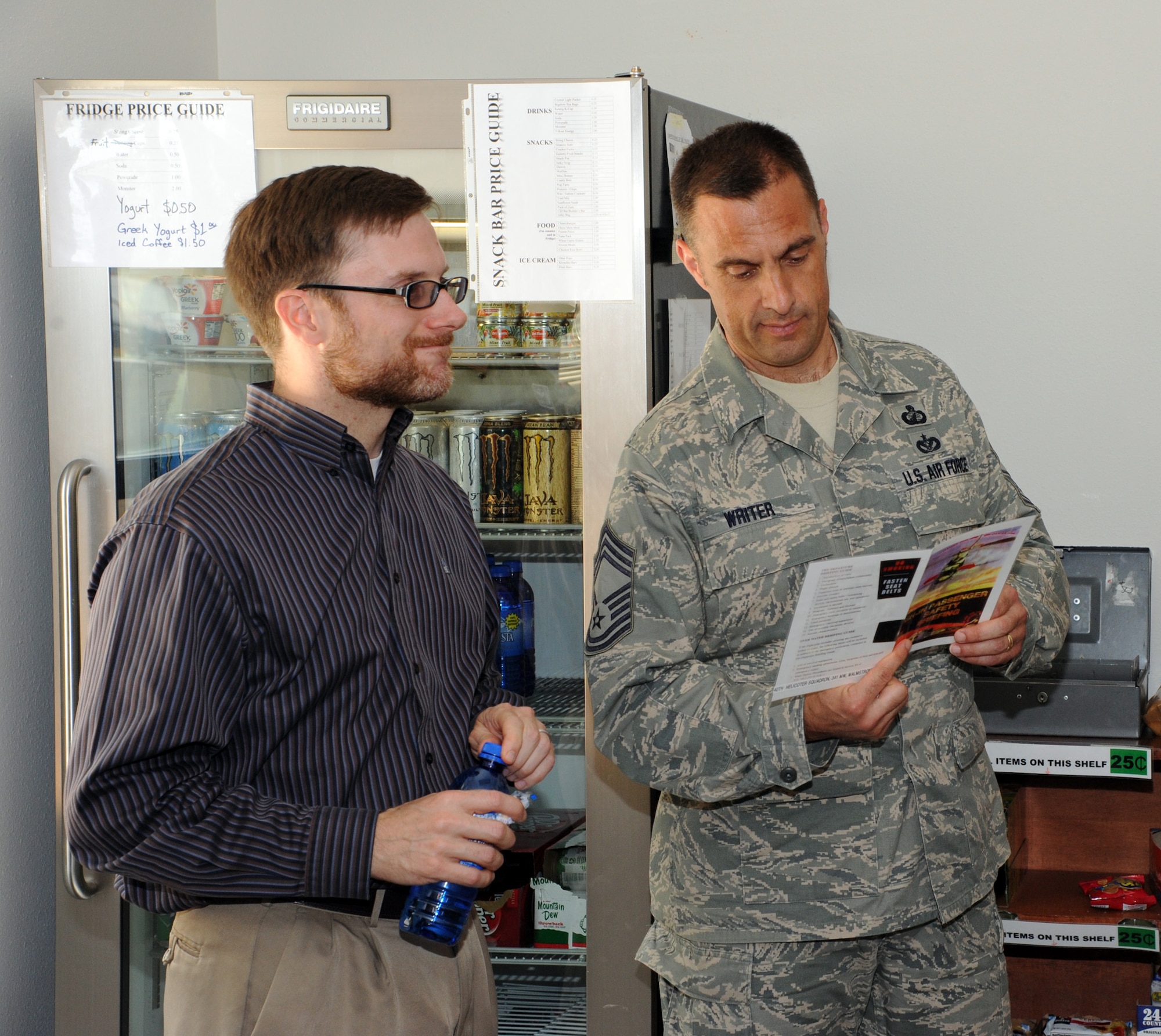 Dr. Jamie Morin, Assistant Secretary of the Air Force for financial management and comptroller, and Chief Master Sgt. John Writer, SAF/FM executive for enlisted matters, read along as they are given a preflight brief June 23. During his visit, Morin got a tour of the 40th Helicopter Squadron which was followed by a helicopter ride to a missile alert facility. (U.S. Air Force photo/ Airman 1st Class Joshua Smoot)
