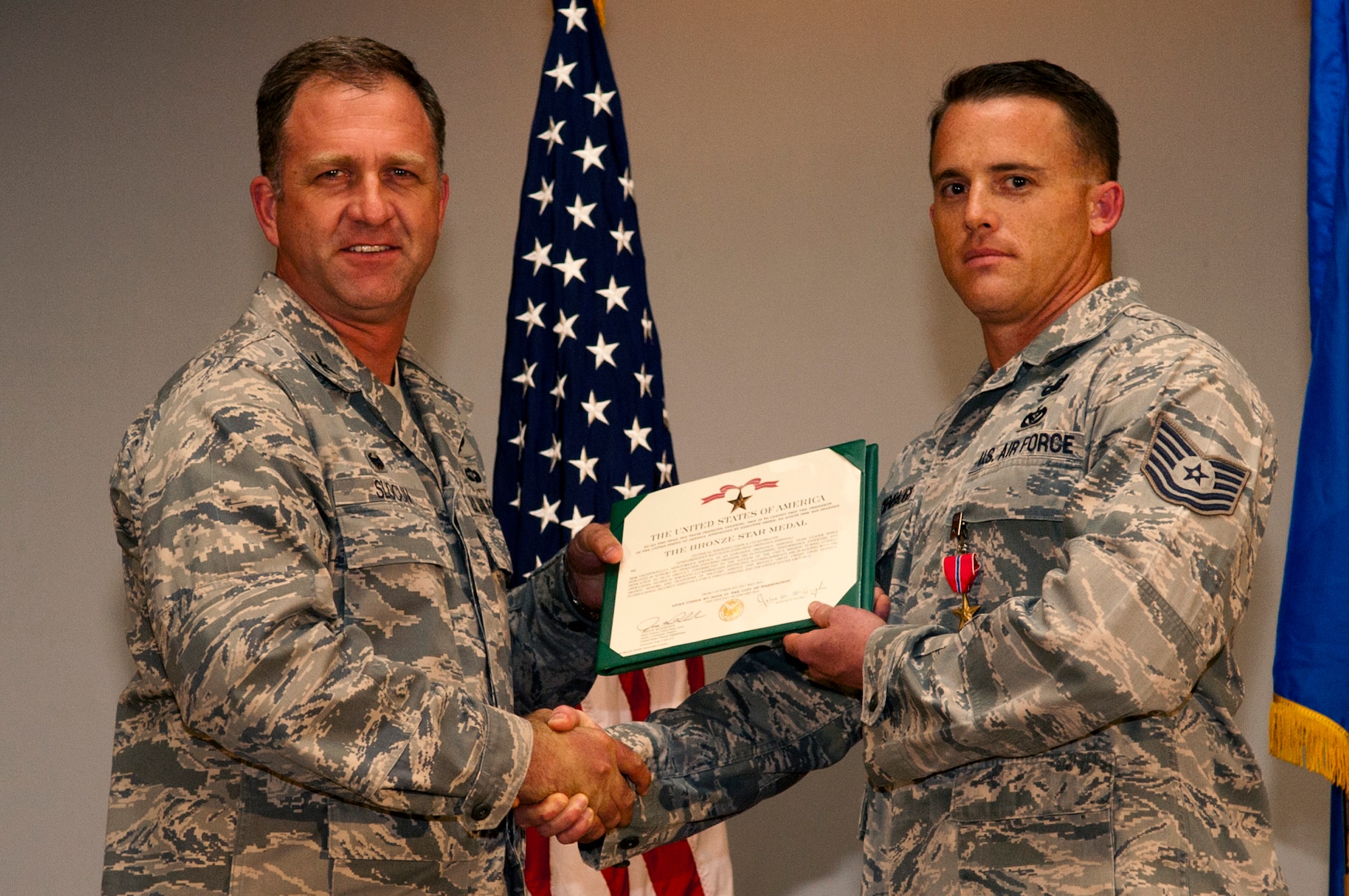 Col. Mark Slocum, 4th Fighter Wing commander, left, presents Tech. Sgt. Jason Luckenbaugh, 4th CES explosive ordnance disposal craftsman, with the Bronze Star medal, June 23, 2014, at Seymour Johnson Air Force Base, North Carolina. Luckenbaugh received the medal for his actions while serving as NCO in charge of the explosive ordnance disposal detachment at Forward Operating Base Frontenac’s, Afghanistan. (U.S. Air Force photo/Airman 1st Class Shawna L. Keyes)