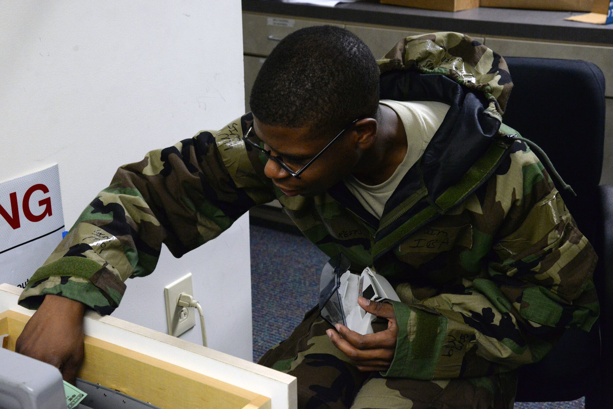 U.S. Air Force Staff Sgt. Isaiah Resto, 20th Comptroller Squadron financial services technician, reaches into a cash drawer to get a stack of fake bills to count during the operational readiness exercise Victory Weasel 07-14, at Shaw Air Force Base, S.C., June 24, 2014. During the exercise, Airmen from across the 20th Fighter Wing must demonstrated and evaluate war-fighting skill. (U.S. Air Force photo by Airman 1st Class Jonathan Bass/Released)