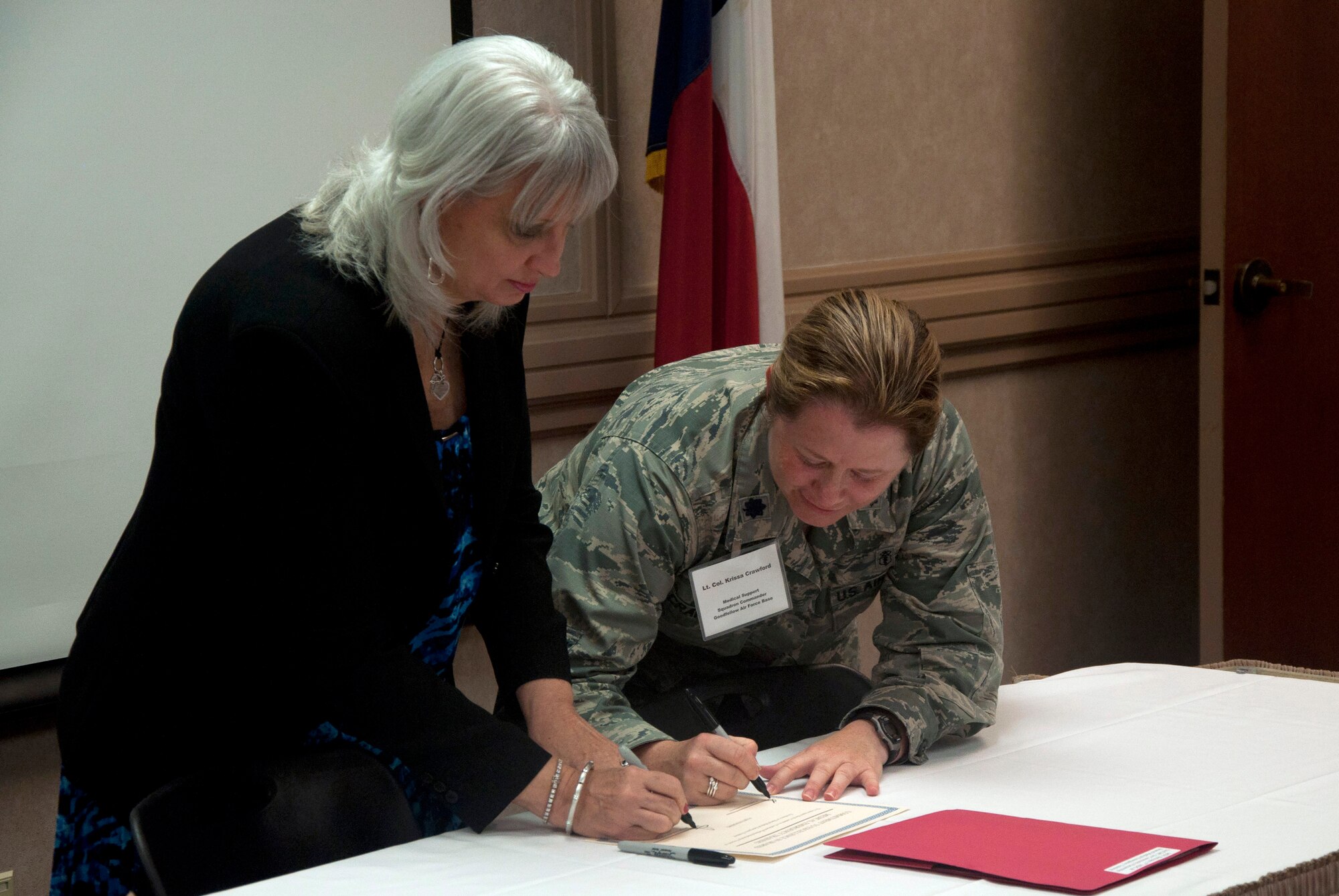 SAN ANGELO, Texas--Lt. Col. Krissa J. Crawford, 17th Medical Support Squadron Commander, and America Farrell, San Angelo Community Medical Center interim CEO, sign a certificate assuring the future MOU’s validity of the partnership to facilitate cooperative training including in-place patient decontamination and medical control center teams at the Angelo State University’s Houston Harte Center June 12. All involved decision makers were not available for the event, but the certificate makes a statement that the initiative will move forward. (U.S. Air Force photo/ Master Sgt. Jennifer Redente)
