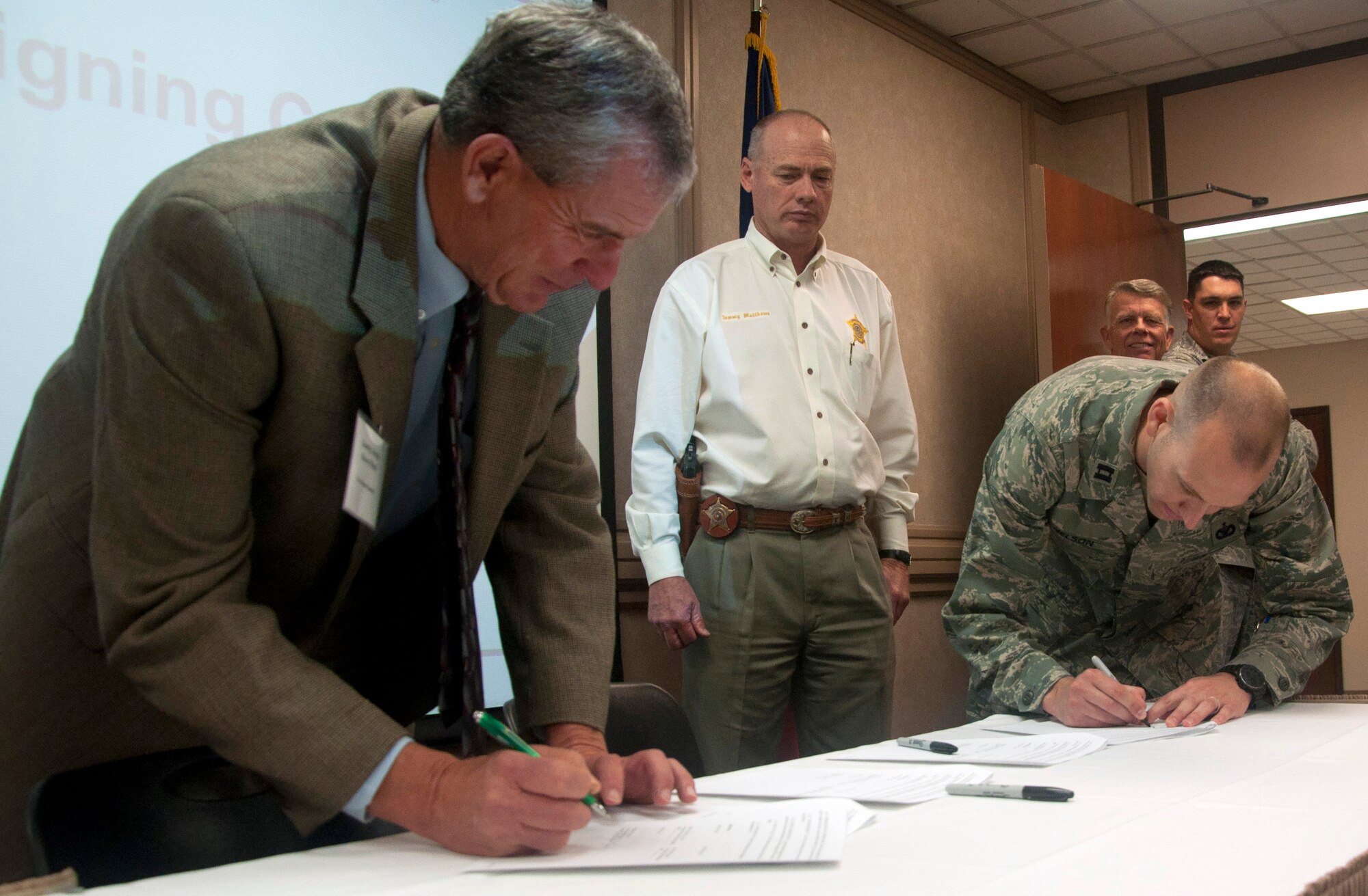 SAN ANGELO, Texas--Tom Green County Judge Stephen C. Floyd and Capt. James J. Nelson, 17th Secruity Forces Squadron Commander, sign copies of the memorandum of understanding allowing the sherrif’s department to utilize the firing range on Goodfellow Air Force Base at the Angelo State University’s Houston Harte Center June 12. Three initiatives came to fruition through a series of meetings since February through the Air Force Community Partnership Initiative. (U.S. Air Force photo/ Master Sgt. Jennifer Redente)