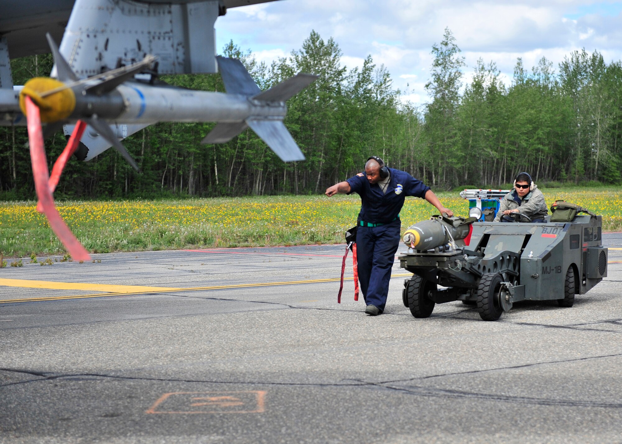 U.S. Air Force Staff Sgt. Kenneth Redmon directs Senior Airman William Howell, both members from the 51st Aircraft Maintenance Squadron assigned to Osan Air Base, South Korea, as they transport a live MK82 AIR munition during RED Flag-Alaska 14-2 June 20, 2014, Eielson Air Force Base, Alaska. The MK82 AIR is a 500-pound bomb with 192-pounds of high explosives. (U.S. Air Force photo by Senior Airman Ashley Nicole Taylor/Released)