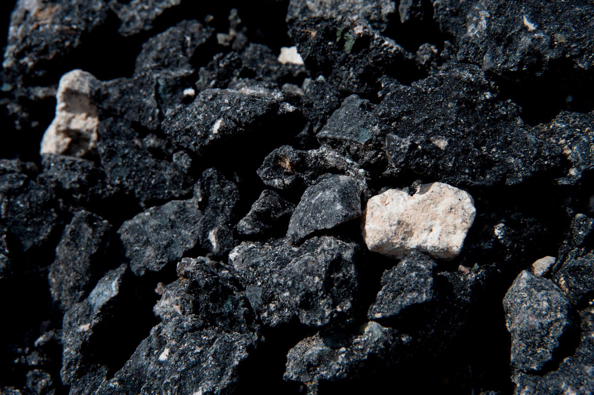 Pieces of pavement pile in mounds on the flightline, as a small portion of the flightline prepares to be turned into a parking lot for U.S. Central Command. The construction started May 2014 and is expected to end Oct. 2014.  (U.S. Air Force photo by Senior Airman Melanie Bulow-Gonterman/Released)
