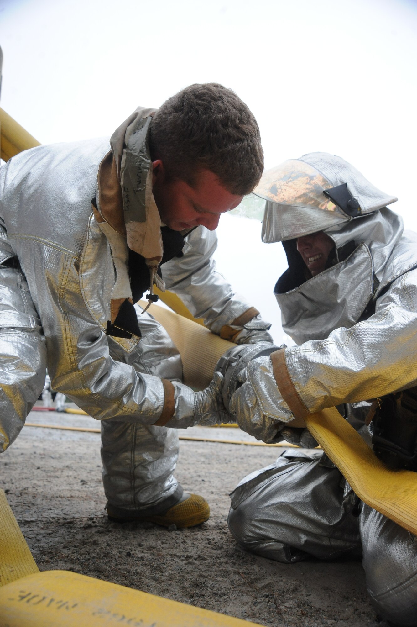 Two 20th Civil Engineer Squadron firefighters attach hoses together, June 23, 2014, at Shaw Air Force Base, S.C. The fire department responded to a simulated aircraft crash and had to simulate safely extinguishing the fire. (U.S. Air Force photo by Airman 1st Class Michael A. Cossaboom)