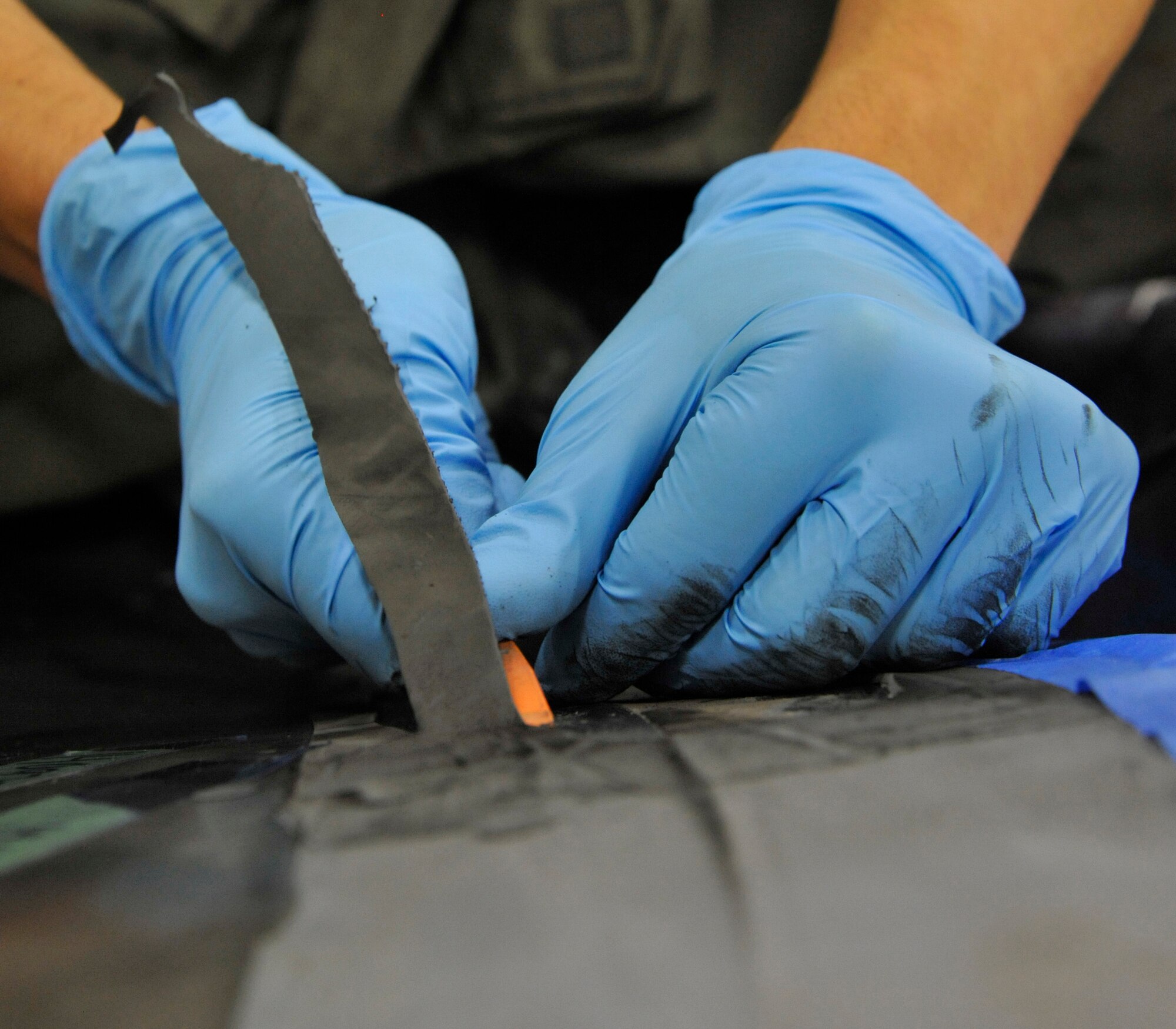 Senior Airman Alexander Ramirez, 509th MXS Low Observable aircraft structural maintainer, removes iron filled elastomer from the B-2 Spirit’s exhaust at Whiteman Air Force Base, Mo., June 12, 2014. The IFE must be removed due to excessive damage from flight. (U.S. Air Force photo by Airman 1st Class Keenan Berry/Released)