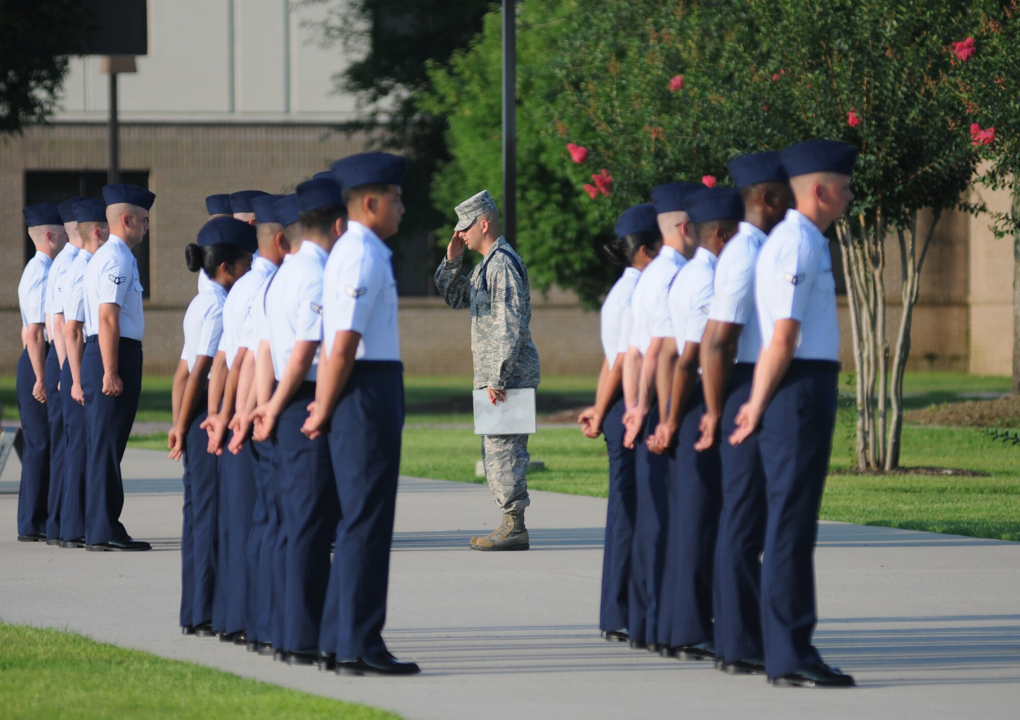 Tech. Sgt. Percy Fish III, 81st Training Group military training leader, returns a salute while conducting an open ranks inspection during the 81st TRG drill down June 20, 2014, at the triangle, Keesler Air Force Base, Miss. The winner of the open ranks portion was the 338th Training Squadron.  (U.S. Air Force photo by Kemberly Groue)