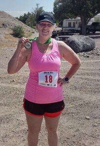 Gina Paige, 366th Force Support Squadron Marketing Department private organization monitor, poses for a photo with her medal after crossing the finish line of the fourth Annual iTri at Strike Dam, Idaho, June 21, 2014. The triathlon included a 300-meter swim, 12.4-mile bike ride and a 3.1-mile run starting and ending at CJ Strike Reservoir. (U.S. Air Force photo by Staff Sgt. Joshua Paige/Released) 