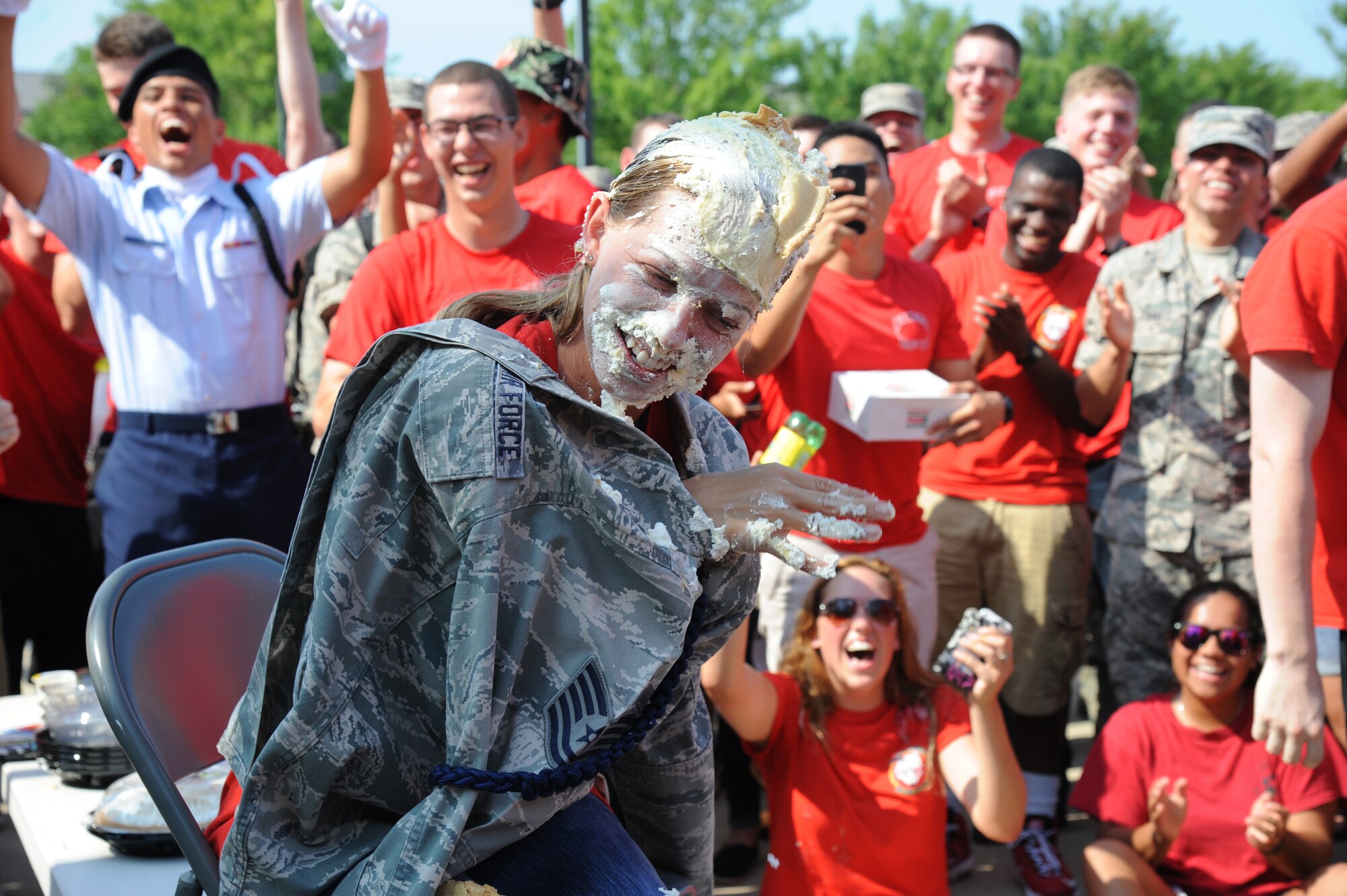 Staff Sgt. Diana Brooks, 336th Training Squadron military training leader, wipes pie from her eyes during a squadron pie-in-the-face fundraiser June 20, 2014, at the Triangle, Keesler Air Force Base, Miss.  The squadron raised over $1,500 to assist with the purchase of a walker for a local boy.  (U.S. Air Force photo by Kemberly Groue)