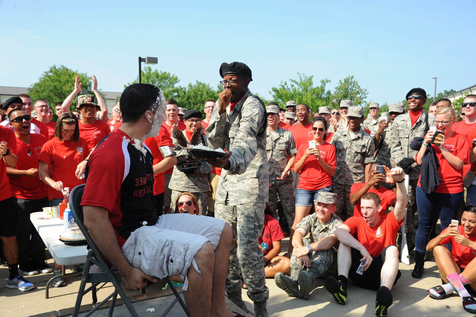 Airman 1st Class Terry Myrick, 336th Training Squadron, reacts after throwing a pie-in-the-face of Tech. Sgt. Markuz Garcia, 336th TRS military training leader, during a squadron fundraiser June 20, 2014, at the Triangle, Keesler Air Force Base, Miss.  The squadron raised more than $1,500 to assist with the purchase of a walker for a local boy.  (U.S. Air Force photo by Kemberly Groue)