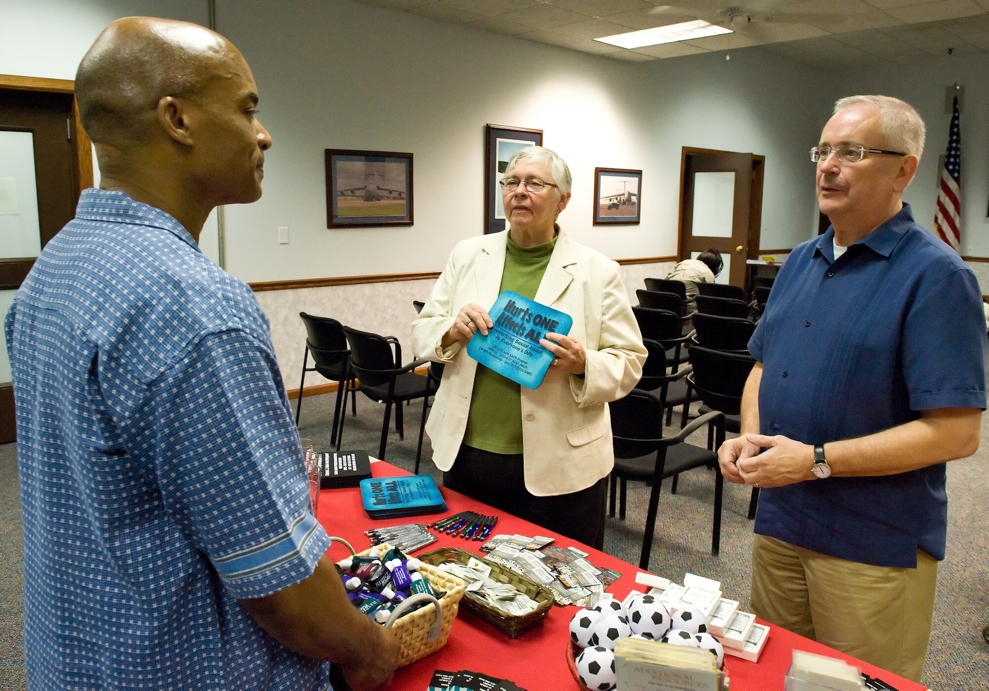 Wil Roberson, 436th Airlift Wing Sexual Assault Prevention and Response Program specialist, talks with Rev. Dusty Pruitt, pastor at the Safe Harbor United Church of Christ, Milton, Del., and Metropolitan Community Church, Rehoboth Beach, Del.; and Steve Elkins, right, Creating A More Positive Rehoboth executive director, Rehoboth Beach, June 20, 2014, at Dover Air Force Base, Del. Roberson briefed Pruitt and Elkins on outreach and educational items provided by his office to Team Dover members. (U.S. Air Force photo/Roland Balik)