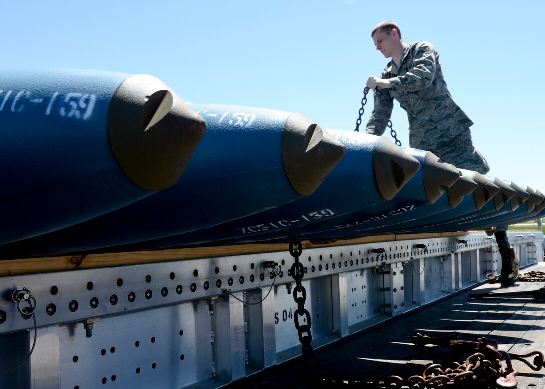 Airman Michael Page, 5th Aircraft Maintenance Squadron weapons load crew member, unchains inert BDU-50 bombs at Ellsworth Air Force Base, S.D., June 9, 2014. Page, along with several other weapons load crew members from Minot Air Force Base, N.D., is dual certified to load both conventional and nuclear munitions in support of Minot’s double-edged mission requirements. (U.S. Air Force photo by Senior Airman Anania Tekurio/Released)