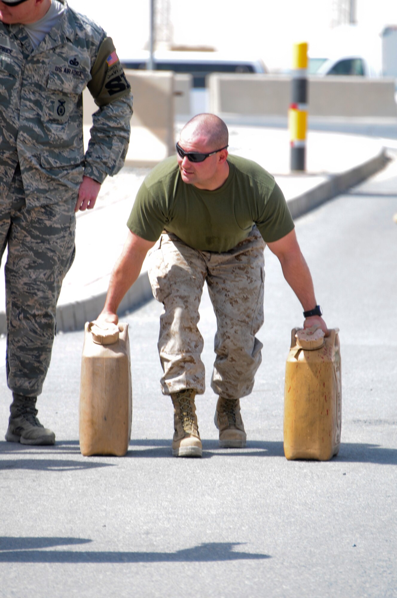 A Marine from the 2nd Law Enforcement Battalion, prepares to race to the finish line carrying two fuel containers of water during a relay race as a part of the Battle of the Badges held June 21, 2014. Military members who wear a badge for military police, fire department or explosive ordinance disposal competed against other military members in multiple events including a ruck march, MRAP pull and relay race to earn the title of best badge wearer. (U.S. Air Force photo by 1st Lt. Holli Nelson)