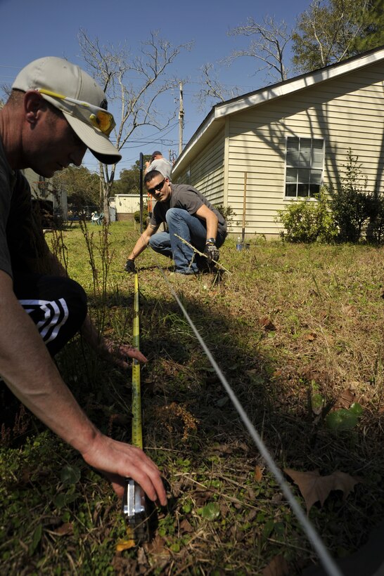 Master Sgt. Jose Nunez, then 325th Force Support Squadron first sergeant, measures the length of the yard at the Habitat for Humanity site, in preparation for building a fence for March 10. The March 10 Comprehensive Airman Fitness Day recently earned the Air Combat Command’s Best CAF Day of the 1st Quarter. (U.S. Air Force photo by Airman 1st Class Solomon Cook)