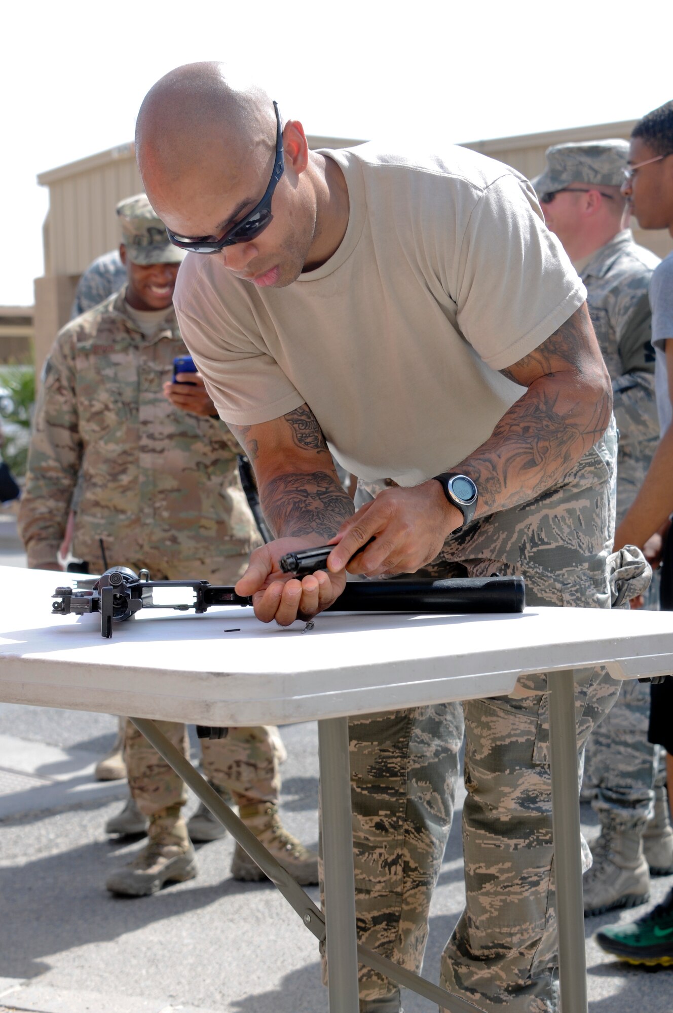 Tech. Sgt. Chris Ducre, 386th Expeditionary Security Forces Squadron, races to assemble an M-4 Carbine weapon during a relay event as a part of the Battle of the Badges held June 21, 2014. Military members who wear a badge for military police, fire department or explosive ordinance disposal competed against other military members in multiple events including a ruck march, MRAP pull and relay race to earn the title of best badge wearer. (U.S. Air Force photo by 1st Lt. Holli Nelson)