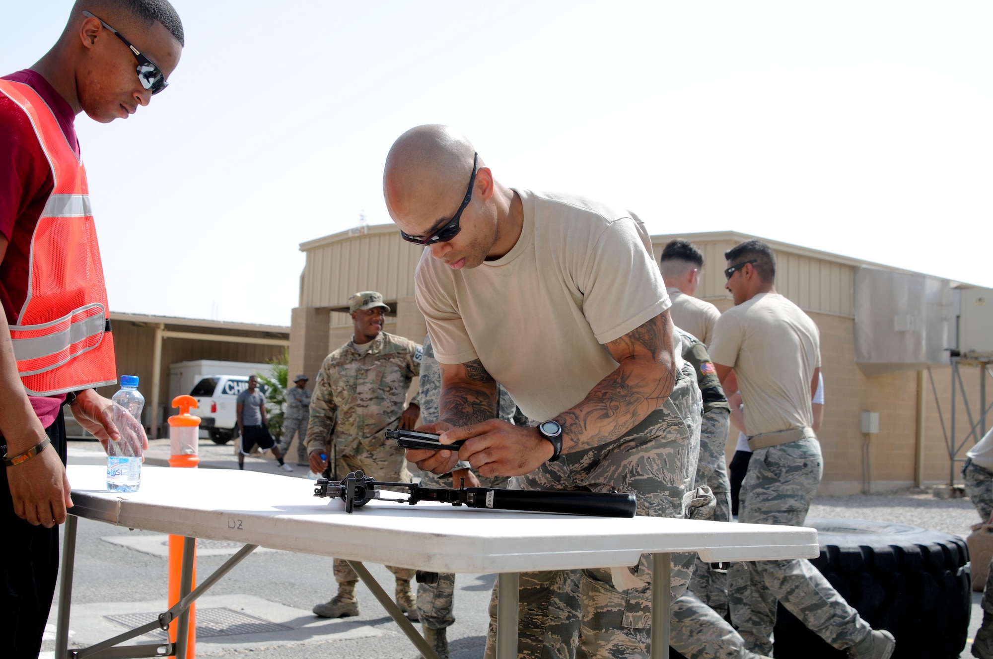 Tech. Sgt. Chris Ducre, 386th Expeditionary Security Forces Squadron, races to assemble an M-4 Carbine weapon during a relay event as a part of the Battle of the Badges held June 21, 2014. Military members who wear a badge for military police, fire department or explosive ordinance disposal competed against other military members in multiple events including a ruck march, MRAP pull and relay race to earn the title of best badge wearer. (U.S. Air Force photo by 1st Lt. Holli Nelson)