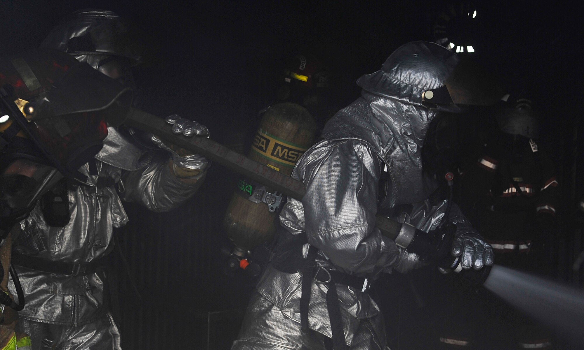 Civil Engineer Squadron firefighters pull the fire hose through the burn house on Ramstein Air Base, Germany, June 5, 2014. The CES firefighters were joined by firefighters from six other bases around the world to participate in Silver Flag training. (U.S. Air Force photo/Airman Larissa Greatwood)