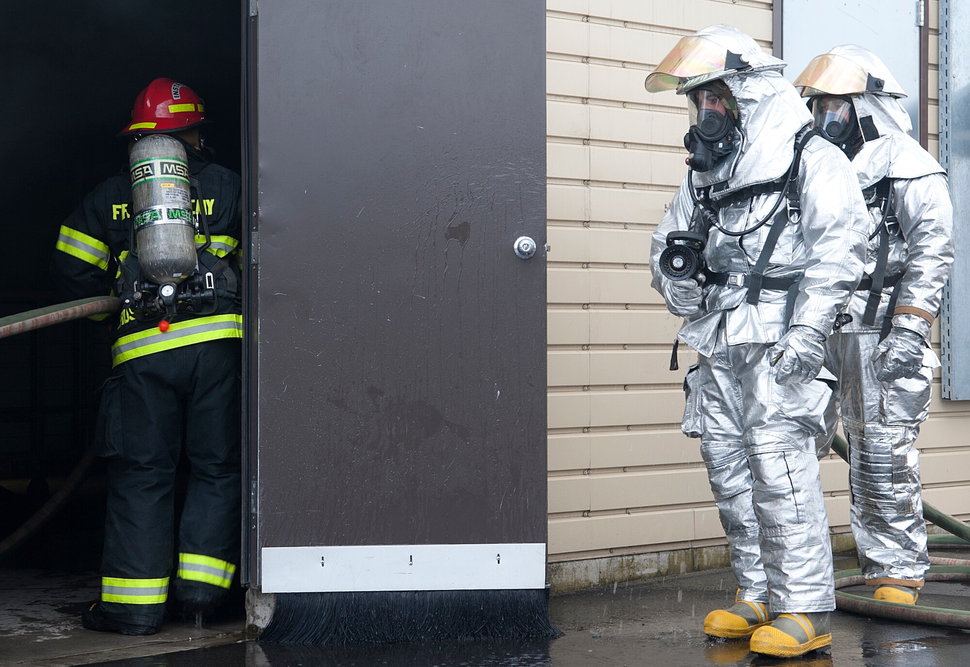 Civil Engineer firefighters wait for their cue to enter the burn house for Silver Flag training on Ramstein Air Base, Germany, June 5, 2014. The CES firefighters participated in a the event to practice putting out fires in the burn house and simulated aircraft. (U.S. Air Force photo/Airman Larissa Greatwood)