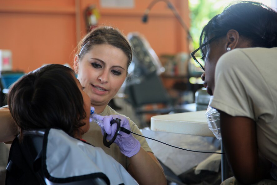 U.S. Air Force Senior Airman Kerry Tromba and Airman 1st Class Jatoni White during a dental cleaning as part of Tropic Care 2014 at Eleele Elementary School, Eleele, Hawai'i, June 17, 2014. Tropic Care 2014 is an Innovative Readiness Training (IRT) exercise that provides training for joint-civil military members while delivering medical care to the people of Kauai. (U.S. Army Photo by Sgt. Bobby Allen/Released)








